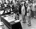 General Douglas MacArthur signs the Japanese surrender document in Tokyo Bay, 2 September 1945.