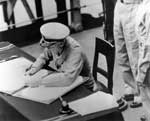 Fleet Admiral Chester Nimitz signs the Japanese surrender document, 2 September 1945.