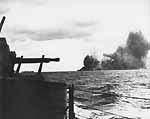 Franklin CV-13 seen from another ship in her formation, after she's hit by a Kamikaze, 30 Oct. 1944