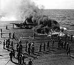 Damage control teams tackle a deck fire caused by a plane belly tank breaking free, January 1945.