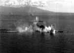 Japan's super-battleship Musashi is obscured by multiple bomb and torpedo hits, 24 October 1944.