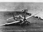 A VT(N)-90 Avenger, its landing gear collapsed, slides to a stop on Enterprise's flight deck.