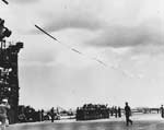 A 578-ft long pennant flying above her, Enterprise pulls out of Pearl Harbor for the US west coast.