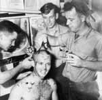 Len C. Thornton AMM 3/c gets a haircut from VT-10 squadron-mates, 22 January 1944.