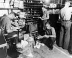 Crewmen sort newly-arrived mail in Enterprise CV-6's Post Office.