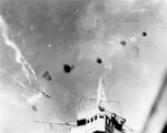 An enemy dive-bomber screams over the bridge of USS Enterprise CV-6, 24 August 1942.