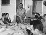 NAG-90 commander William I. Martin tells a story in Enterprise's wardroom, 24 December 1944.