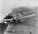 A plane wrenched from its moorings by a near miss skitters across the Big E's flight deck.