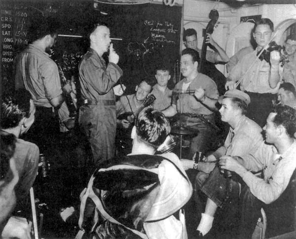 Men drown jitters in music in the VF(N)-90 Ready Room, the night before the Tokyo Raids.