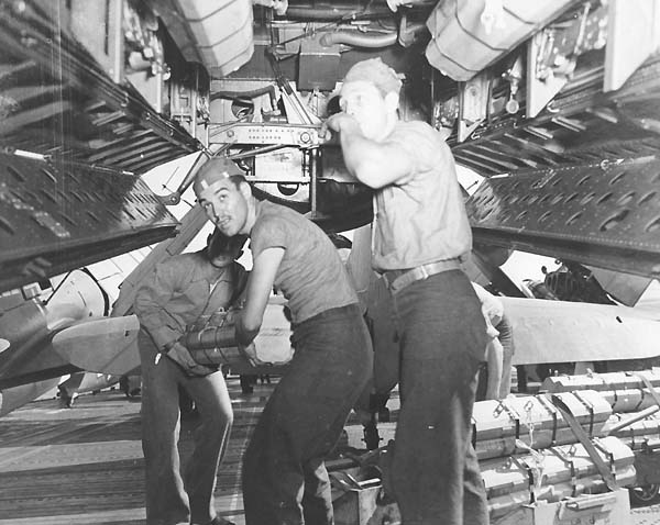 Ordnancemen aboard Enterprise CV-6 load TBM Avengers with fragmentation bombs, 10 October 1944.