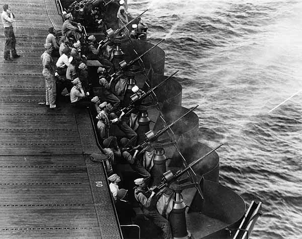 New 20mm guns on Enterprise CV-6 fire at a towed target off Hawaii, March 1942.