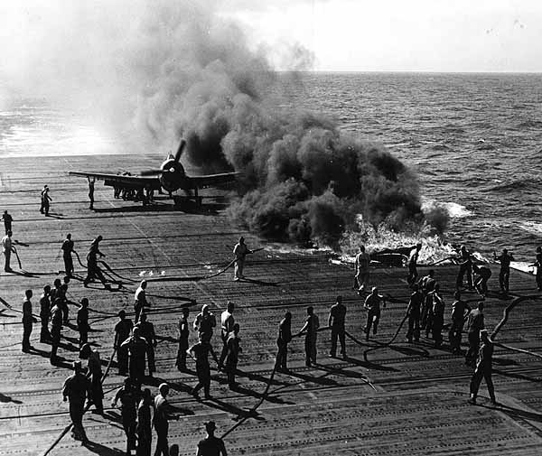 Damage control teams tackle a deck fire caused by a plane belly tank breaking free, January 1945.