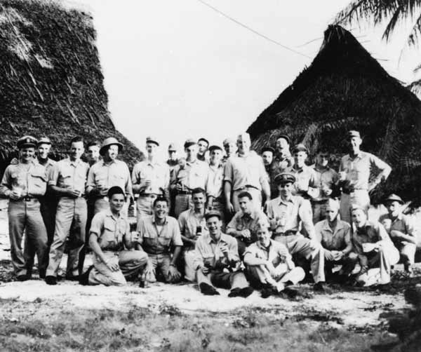 NAG-90 officers, beverages securely in hand, relax on Mog Mog island, Ulithi Atoll.