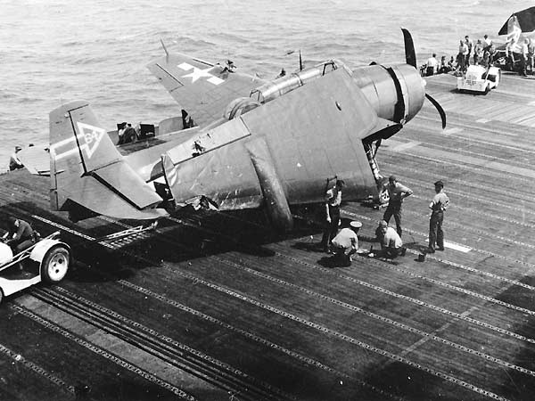 An aircraft tractor hauls away LT James Moore's damaged Avenger, 11 February 1945.