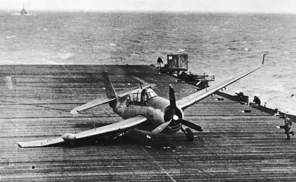 A VT(N)-90 Avenger, its landing gear collapsed, slides to a stop on Enterprise's flight deck.