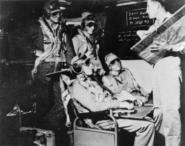 NAG-90 pilots are briefed in their ready room. Goggles help preserve their night vision.