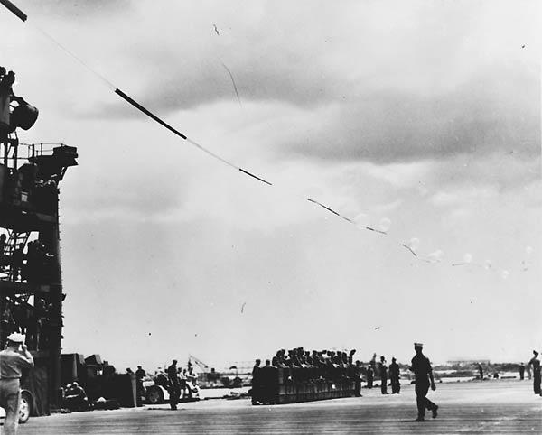 A 578-ft long pennant flying above her, Enterprise pulls out of Pearl Harbor for the US west coast.