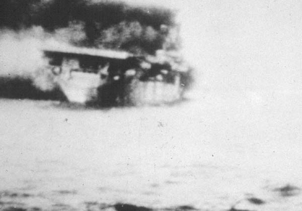 A ghostly photo of Wasp CV-7 listing and on fire, 15 September 1942.