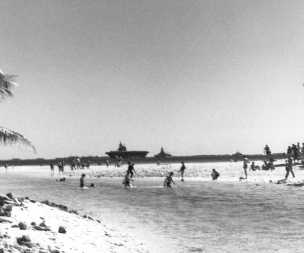 Enterprise CV-6 rests at anchor while her men take a dip in Majuro Atoll, 1 March 1944.