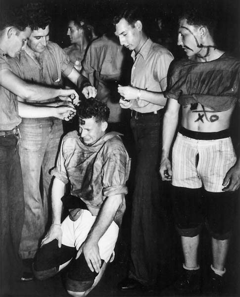 M. J. Carlson AMM 1/c grimaces while squadron-mates cut his hair: pollywog initiation, 22 Jan 1944.