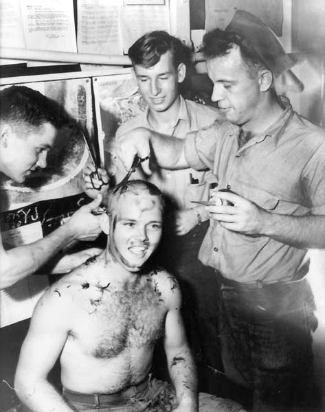 Len C. Thornton AMM 3/c gets a haircut from VT-10 squadron-mates, 22 January 1944.