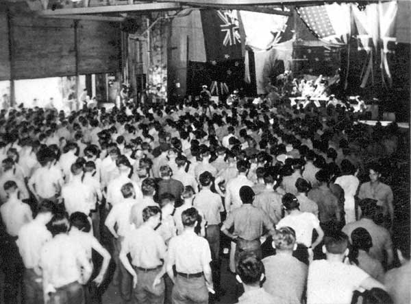 Enterprise CV-6's hangar deck is packed for a performance by the crew of HMNZS Leander.