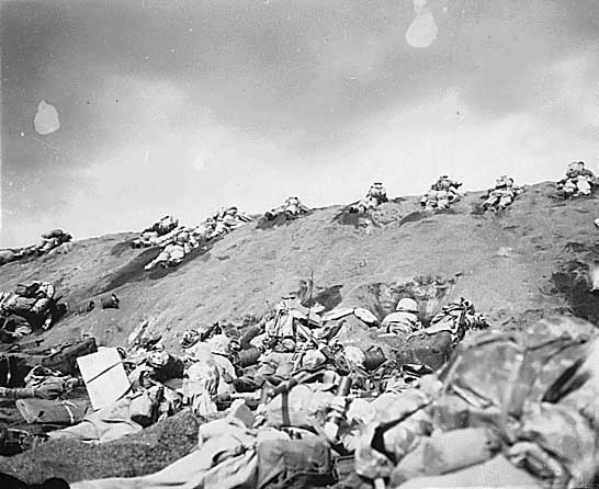 Marines of the Fifth Division creep forward under heavy enemy fire: Iwo Jima, 19 February 1945.