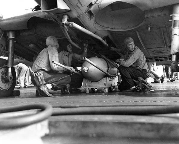 Ordnancemen aboard Enterprise CV-6 load a 500 lb. bomb on a Dauntless SBD, 7 August 1942.