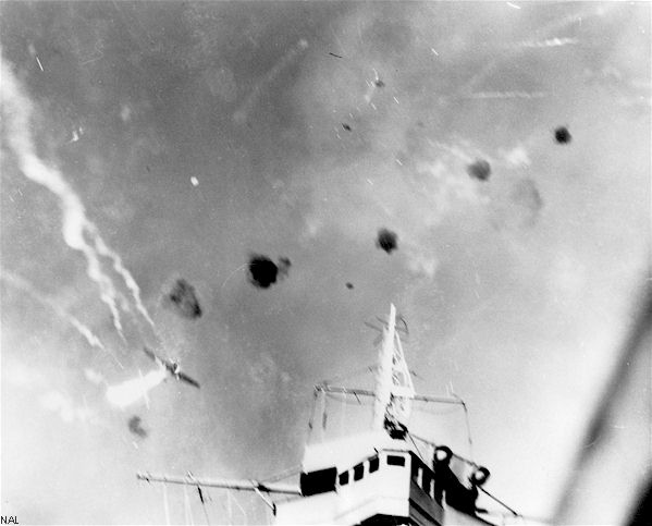 An enemy dive-bomber screams over the bridge of USS Enterprise CV-6, 24 August 1942.