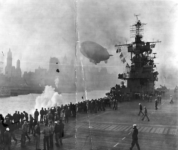 Men aboard Enterprise CV-6 gather at the rail as she nears downtown Manhattan, 17 October 1945.